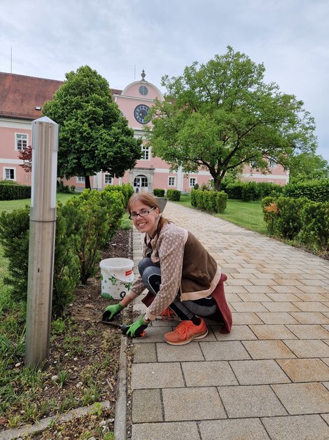 Bewohnerin beim Unkrautjäten