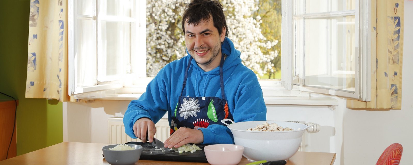 Bewohner am Tisch sitzend beim Gemüseschneiden