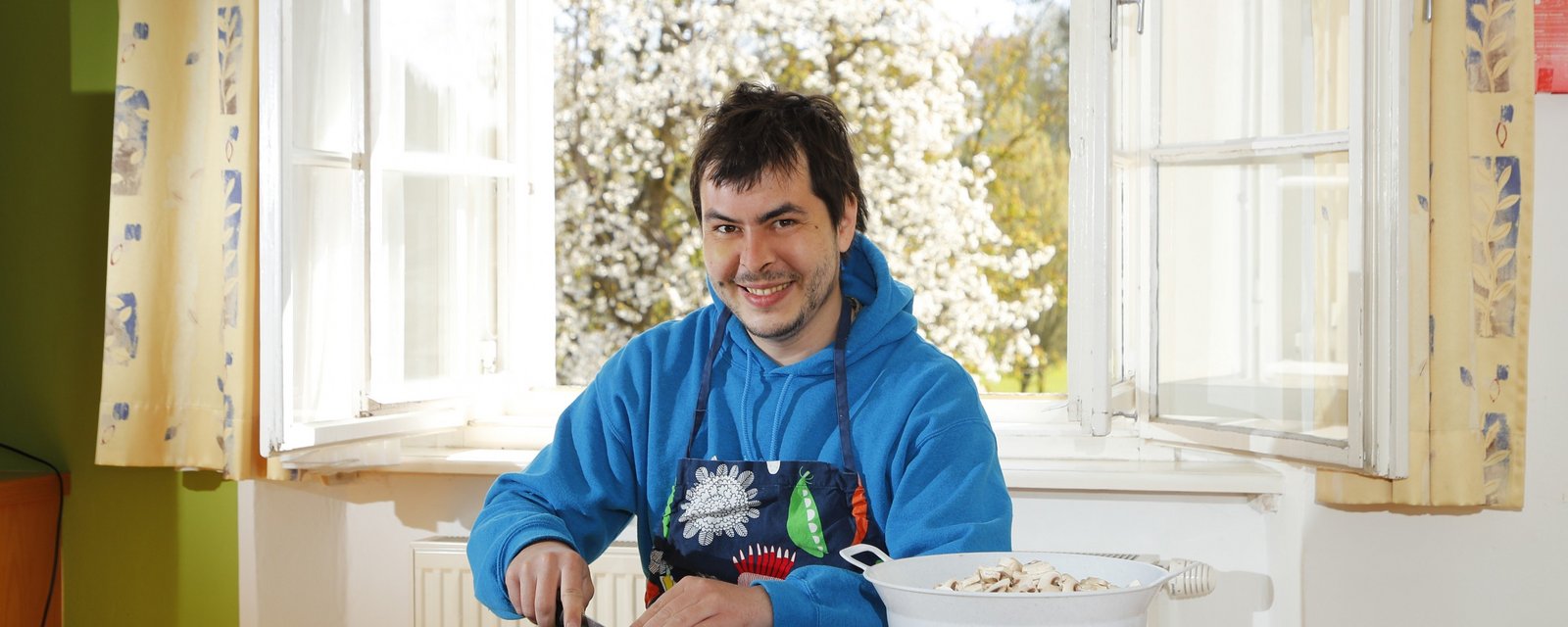 Bewohner am Tisch sitzend beim Gemüseschneiden