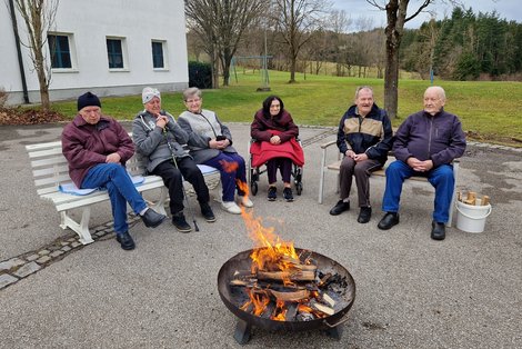 Bewohnergruppe bei Feuerschale